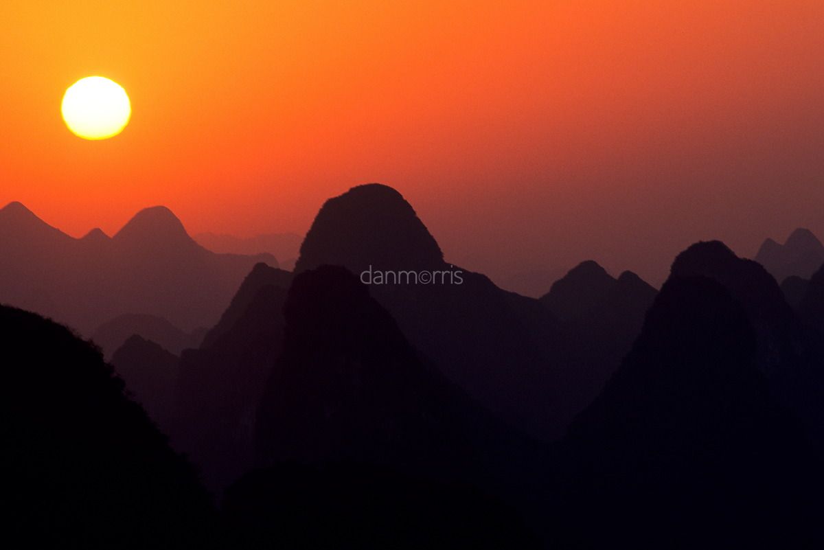 Yangshuo Sunrise Sun rises over landscape of myriad silhouetted karst towers, Yangshuo, Guilin, China (Dan Morris)