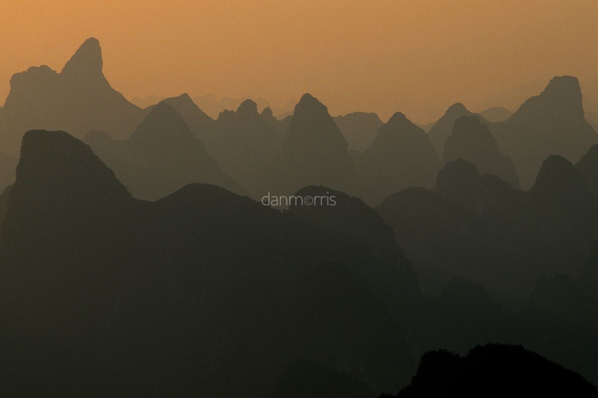 Yangshuo Sunrise Early morning light over landscape of myriad silhouetted karst towers, Yangshuo, Guilin, China (Dan Morris)
